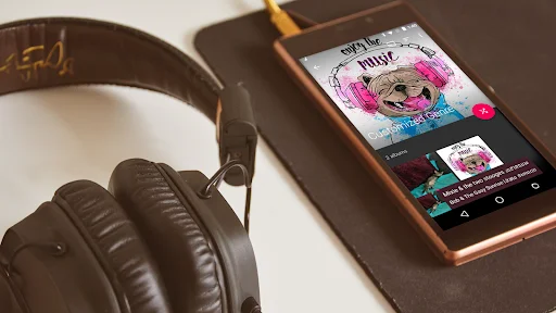 Fuel Music Player interface on phone next to headphones displaying colorful album artwork and music library